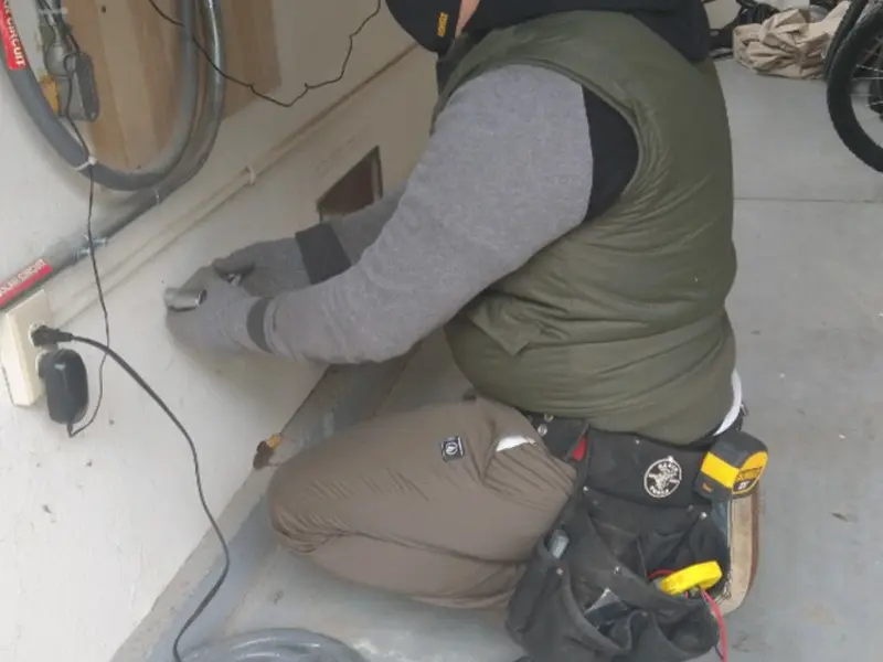 Electrician performing outlet wiring in a Woodburn garage